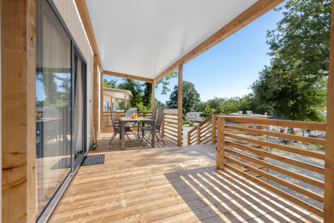 Holzterrasse des Mobile home Pula auf Camping Bijela Uvala, Kroatien, mit Sitzgruppe und Campingblick.