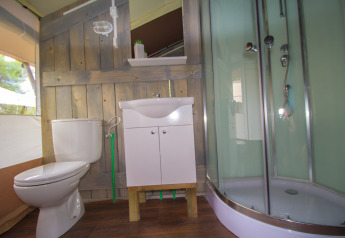 Bagno in tenda safari con WC, lavandino e doccia al Camping Bijela Uvala in Croazia.