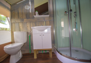 Bagno in tenda safari con WC, lavandino e doccia al Camping Bijela Uvala in Croazia.
