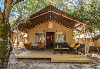 Safari tent Lodge met airconditioning op Camping Bijela Uvala in Kroatië, met een gezellige zithoek buiten.