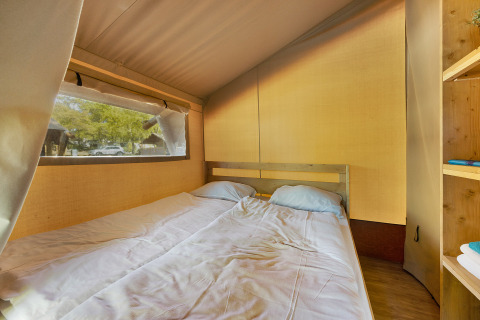 Innenansicht eines Safari Tent Lodge auf Camping Aminess Maravea in Kroatien mit Doppelbett und Fenster.