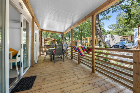 Véranda en bois de Mobile home Fuskulin au Camping Bijela Uvala en Croatie, avec mobilier extérieur.