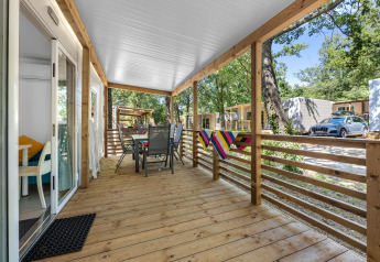 Wooden porch of Mobile home Fuskulin at Camping Bijela Uvala in Croatia with outdoor furniture.