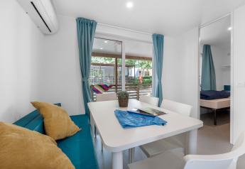Vista interna di Mobile home Fuskulin al Camping Bijela Uvala in Croazia con zona pranzo.