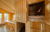 Interieur van een safaritent bij Camping Bijela Uvala in Kroatië, met eethoek en ingebouwd bed.