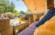 Udsigt indefra en luksuriøs safaritelt ved Camping Bijela Uvala i Kroatien med terrasse og møbler.