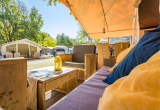 Vista desde el interior de una tienda safari de lujo en Camping Bijela Uvala, Croacia, con terraza amueblada.