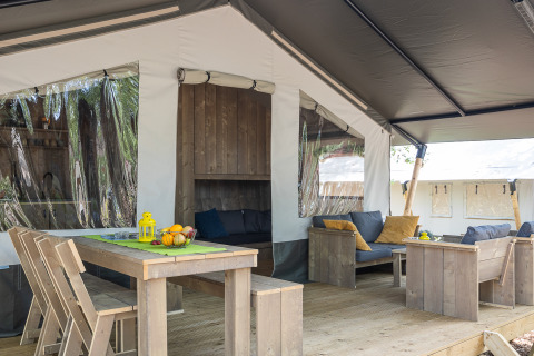 Safaritent met sanitaire voorzieningen op Camping Aminess Maravea in Kroatië, ingericht met houten meubels.