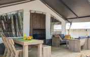 Safari tent with sanitary facilities at Camping Aminess Maravea in Croatia, featuring wooden furniture and decor.