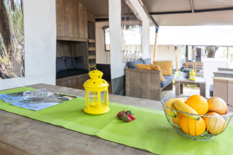 Safari tent met sanitair bij Camping Aminess Maravea in Kroatië, met fruitschaal en gele lantaarn.