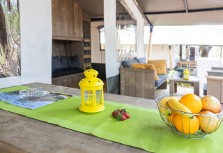 Safari tent met sanitair bij Camping Aminess Maravea in Kroatië, met fruitschaal en gele lantaarn.