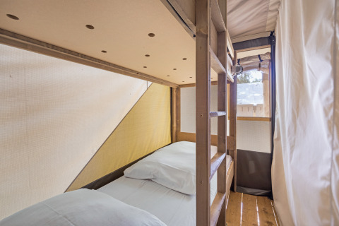 Interno di tenda safari con letti a castello e legno al Camping Aminess Maravea in Croazia.