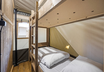 Letto a castello in legno dentro tenda safari con servizi igienici privati al Camping Aminess Maravea in Croazia.