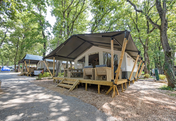 Tenda safari con servizi igienici privati al Camping Aminess Maravea, immersa tra gli alberi in Croazia.