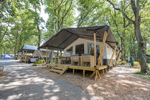 Safari tent with private sanitary facilities at Camping Aminess Maravea, surrounded by trees in Croatia.