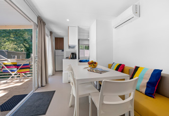 Casa mobile luminosa al Camping Bijela Uvala, Croazia, interni moderni, cuscini colorati e terrazza.