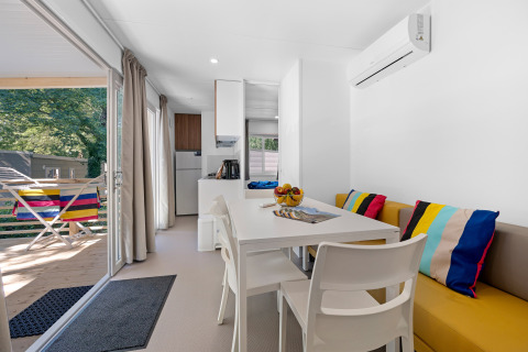 Casa mobile luminosa al Camping Bijela Uvala, Croazia, interni moderni, cuscini colorati e terrazza.