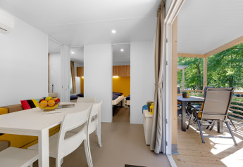 Moderne stacaravan in Porec, Camping Bijela Uvala, Kroatië, met heldere leefruimte en terras in het groen.
