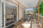 Veranda van Mobile home Porec met eettafel bij Camping Bijela Uvala Kroatië, omringd door bomen.