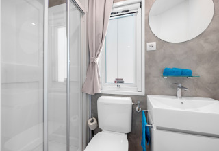 Modernes Bad im Mobile Home Porec, Camping Bijela Uvala, Kroatien, mit Dusche, WC und Waschbecken.