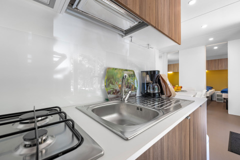 Cocina moderna de cabaña en Mobile home Porec, Camping Bijela Uvala, Croacia con fogón y cafetera.