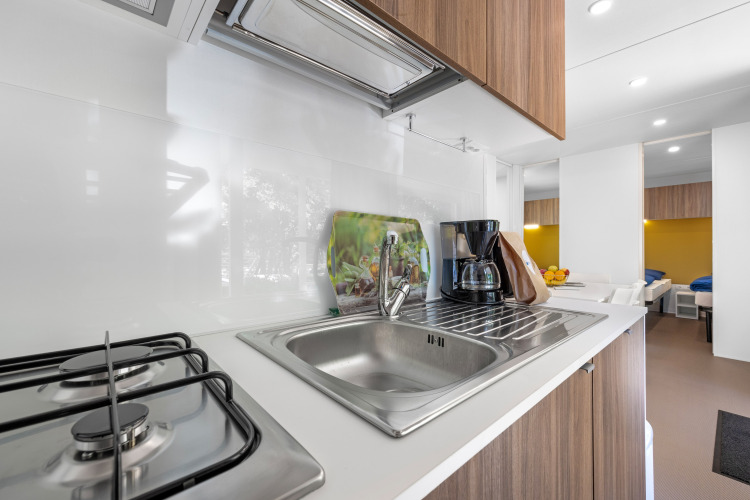 Cocina moderna de cabaña en Mobile home Porec, Camping Bijela Uvala, Croacia con fogón y cafetera.