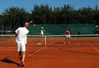 Persone che giocano a tennis su un campo all’aperto al Koversada Camping Resort, Istria, Croazia, giornata di sole.