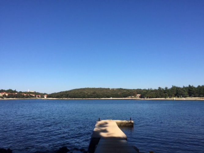 Steiger aan rustig water bij Koversada Camping Resort in Istrië, Kroatië, onder een heldere blauwe lucht.
