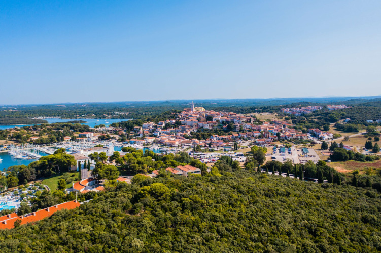 Luftaufnahme vom Ferienpark Camping Porto Sole in Istrien, Kroatien, umgeben von Wald und Küstenstadt.