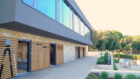Edificio moderno con doghe in legno e grandi finestre al Camping Porto Sole, villaggio turistico in Istria, Croazia.