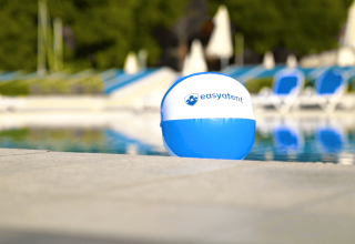 En blå og hvid strandbold med 'easytent' logo ved siden af en pool i Camping Porto Sole, Istrien, Kroatien.