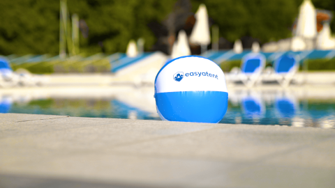 En blå og hvid strandbold med 'easytent' logo ved siden af en pool i Camping Porto Sole, Istrien, Kroatien.