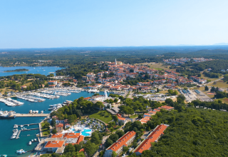 Vista aerea di Camping Porto Sole in Istria, Croazia, con porto turistico, città storica e verde lussureggiante.