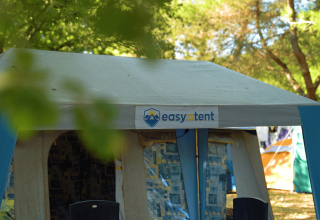 Una tenda con il cartello 'easytent' al Camping Porto Sole, circondata da alberi in Istria, Croazia.