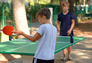 Due ragazzi giocano a ping pong all'aperto al Camping Porto Sole, un villaggio turistico in Istria, Croazia.