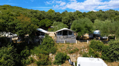 Vista de Camping Porto Sole en Istria, Croacia, con cabañas de camping y árboles verdes bajo el sol.