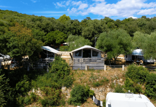 Udsigt over Camping Porto Sole i Istrien, Kroatien, omgivet af grønne træer og feriehytter om sommeren.