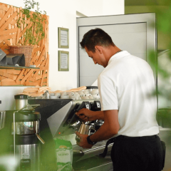 Barista maakt koffie bij een espressomachine in Camping Porto Sole, een vakantiepark in Istrië, Kroatië.