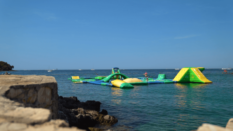 Aufblasbarer Wasserpark im Meer bei Camping Porto Sole, Istrien, Kroatien an einem sonnigen Tag.