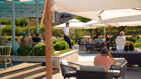 Outdoor seating area at Camping Porto Sole in Istria, Croatia, with guests relaxing under umbrellas.