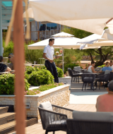 Buitenruimte van Camping Porto Sole in Istrië, Kroatië, met gasten ontspannen onder parasols.
