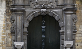 Puerta de piedra histórica con leones, escudo y detalles tallados en Veere, Zelanda, Países Bajos.