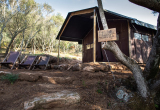 Tent en ligstoelen bij Feather Down Figari Corsica, een vakantiepark in de natuur op Corsica, Frankrijk.