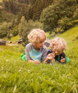 Dos niños juegan en un prado con flores en Feather Down Hilserhof, un parque vacacional en Baden-Württemberg, Alemania.