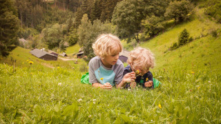 Dos niños juegan en un prado con flores en Feather Down Hilserhof, un parque vacacional en Baden-Württemberg, Alemania.