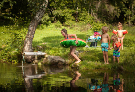 Niños jugando y nadando en un estanque natural, cerca de Triberg en Baden-Württemberg, Alemania.