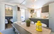 Licht en modern interieur van mobile home Capri op Camping Zelena Laguna in Kroatië, met keuken en eethoek.