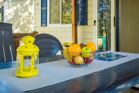 Terrassentisch am Mobile home Capri im Camping Zelena Laguna, Kroatien, mit Obstschale und Laterne.