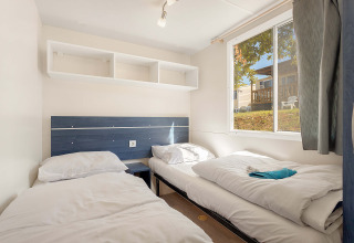 Værelse med to enkeltsenge i Mobile home Capri, Camping Zelena Laguna, Kroatien, med vindue og hylder.