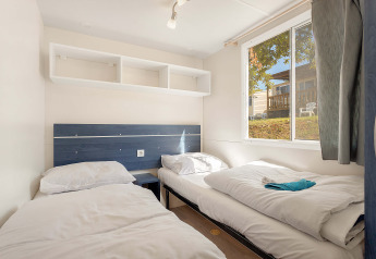 Værelse med to enkeltsenge i Mobile home Capri, Camping Zelena Laguna, Kroatien, med vindue og hylder.